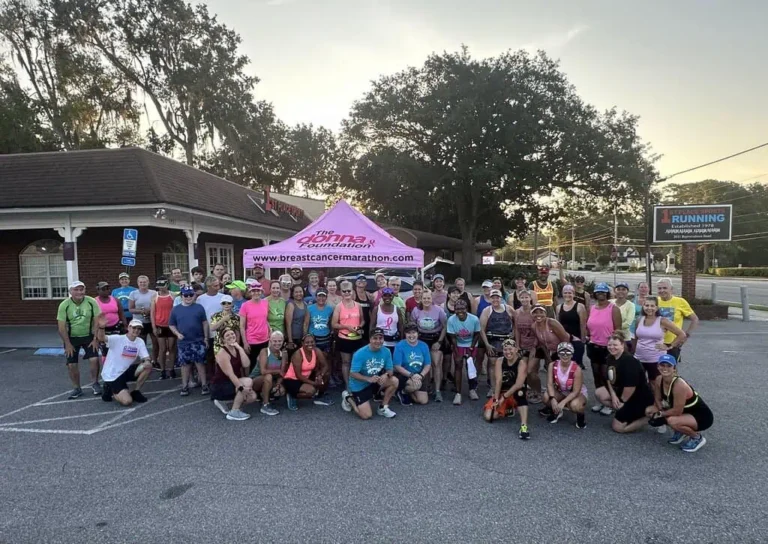 A group of runners pose at a breast cancer marathon.