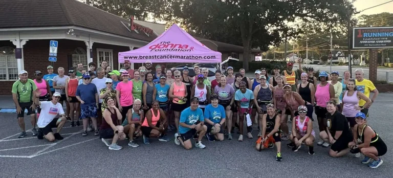 A group of runners pose at a breast cancer marathon.