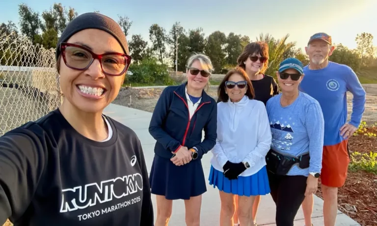 Group of runners taking a selfie outdoors wearing athletic gear