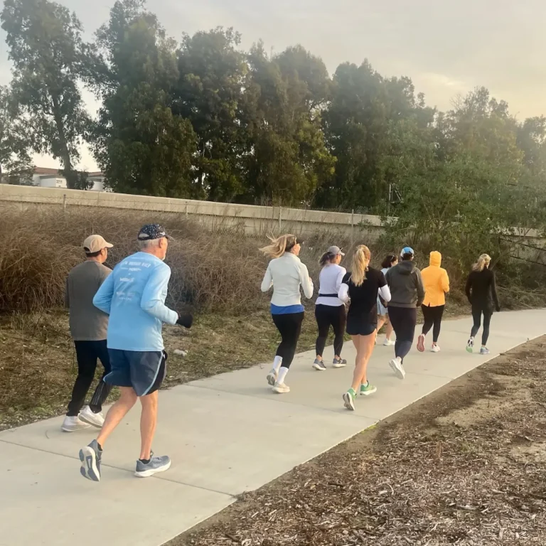 Group of runners jogging together on outdoor concrete path